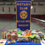 Members of the West Plains Sunrise Rotary Club display some of the 407 pounds of food they collected.