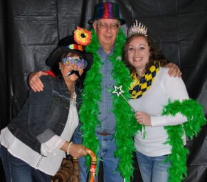 Rotarians Tammy Wickham, Henry Niles, Dori Shirley try on photo booth props during the 2016 mouse races.